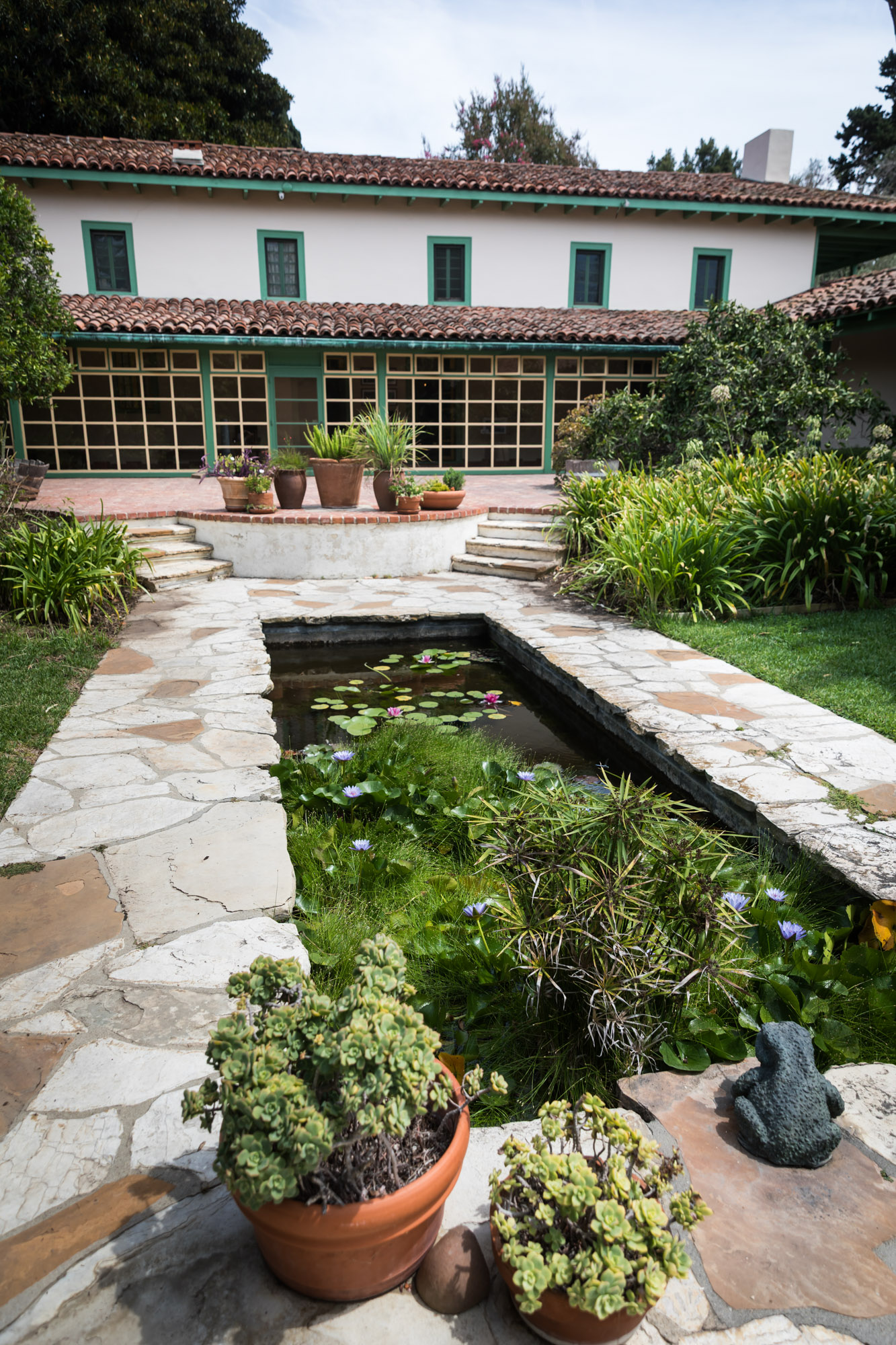 The tropical pond surrounded by stones in front of the main house at Rancho Los Cerritos for an article on where to propose in Long Beach
