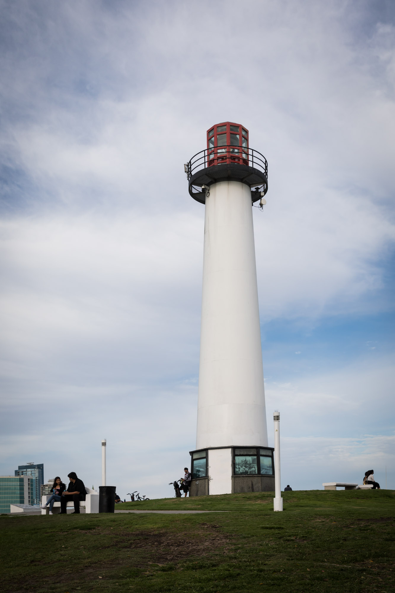 Lions Lighthouse viewed from the ground with a couple sitting in front on a bench for an article on where to propose in Long Beach