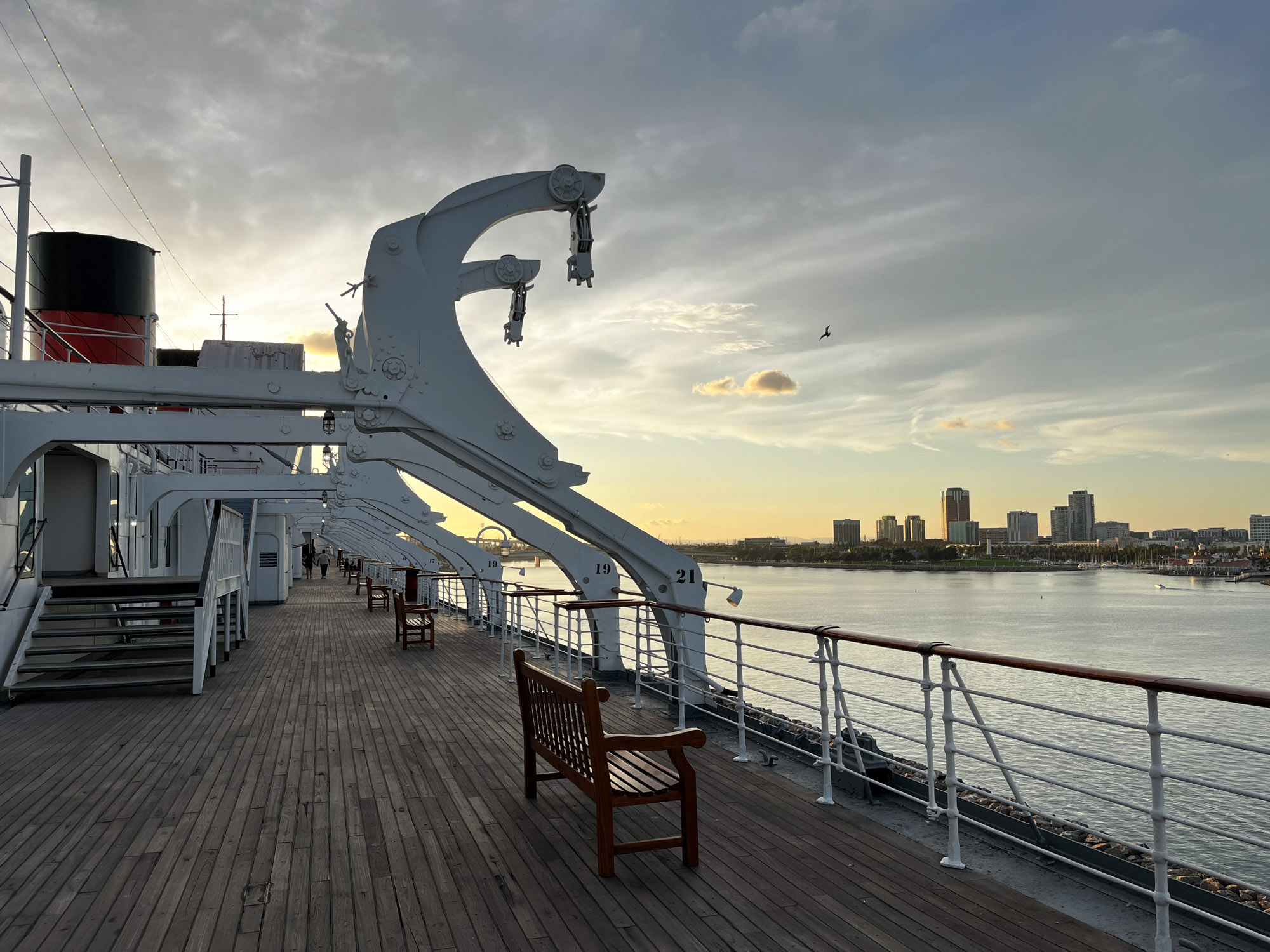 View of the deck of the Queen Mary with gantries overhead and the Long Beach skyline in the background for an article on where to propose in Long Beach