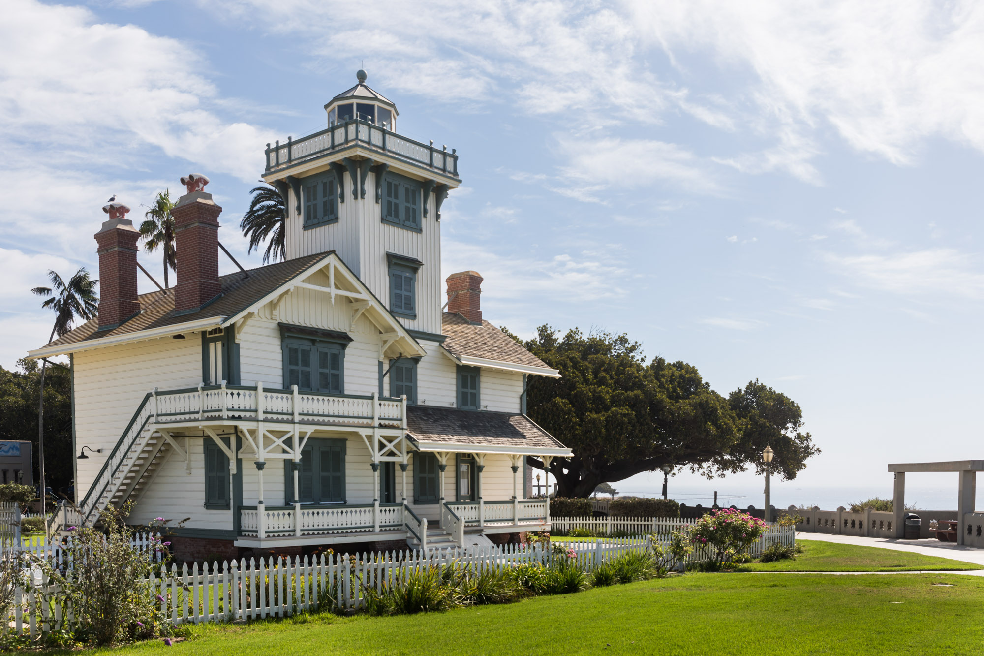 Point Fermin Lighthouse with white gate and grass in front for an article on where to propose in Long Beach