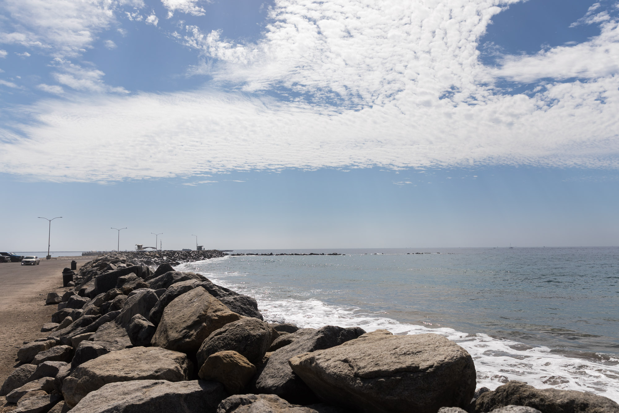 The rock jetty at Cabrillo Beach with clouds overhead and the Pacific Ocean for an article on where to propose in Long Beach