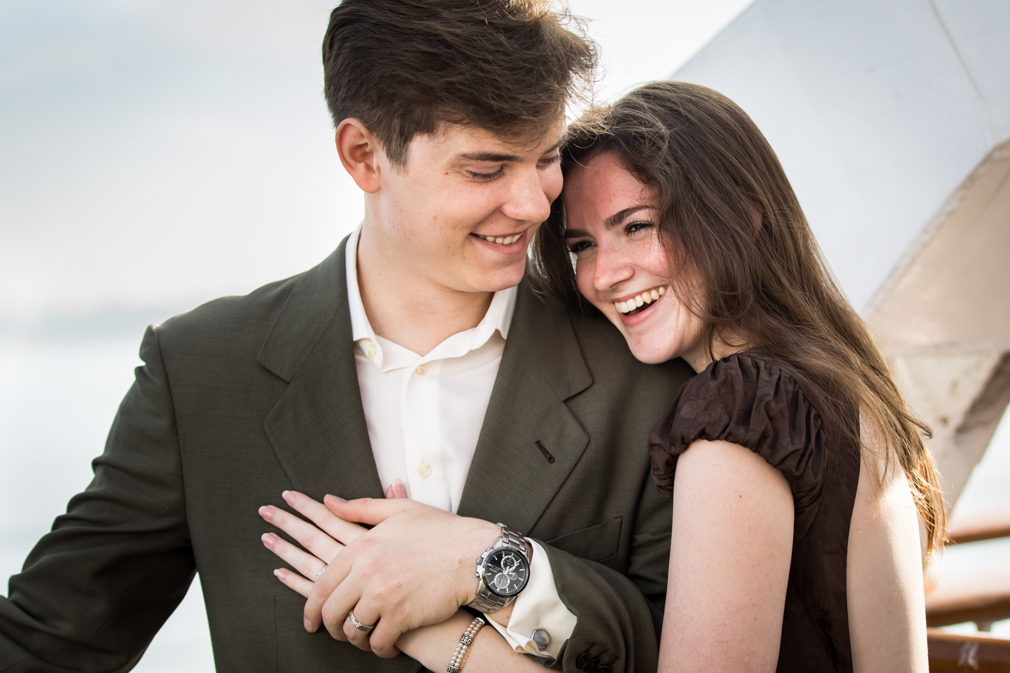 Woman laughing against the man's shoulder, a joyful portrait from their Queen Mary photo shoot