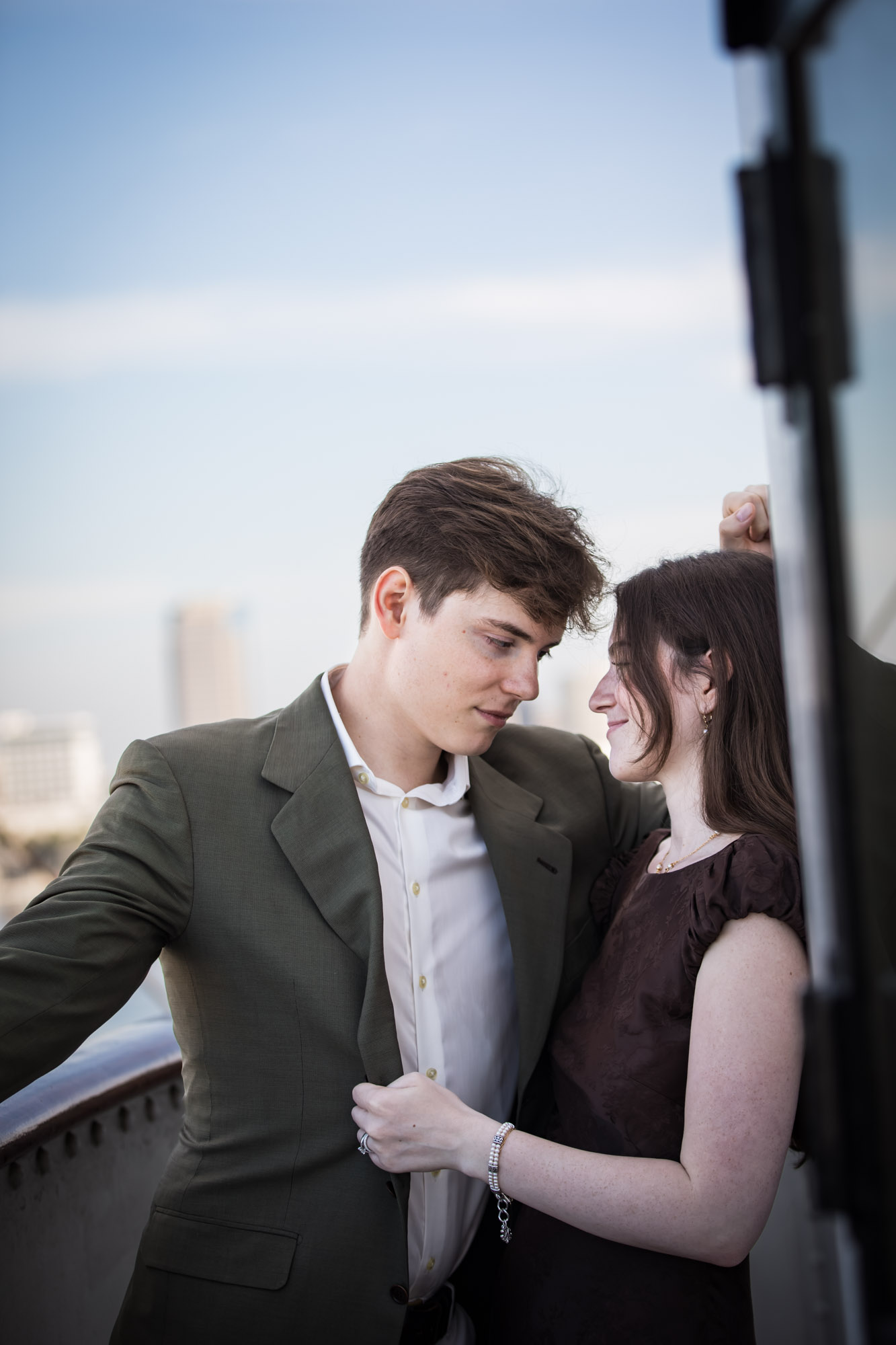 Man gazing down at the woman with her hand on his jacket, a quiet moment from a Queen Mary photo shoot
