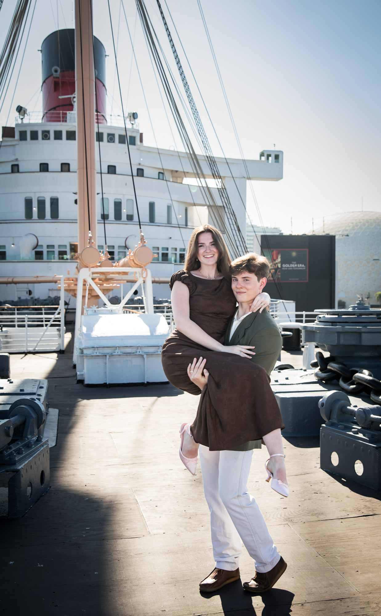 Laughing woman carried in her fiancé's arms on the ship's deck, by a Los Angeles photographer