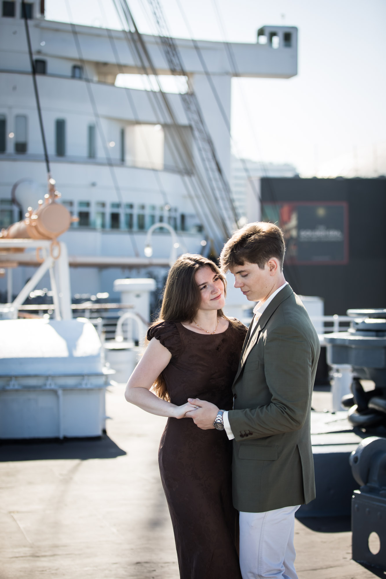 Couple slow dancing hand in hand with the ship's white superstructure behind them, by a Los Angeles photographer