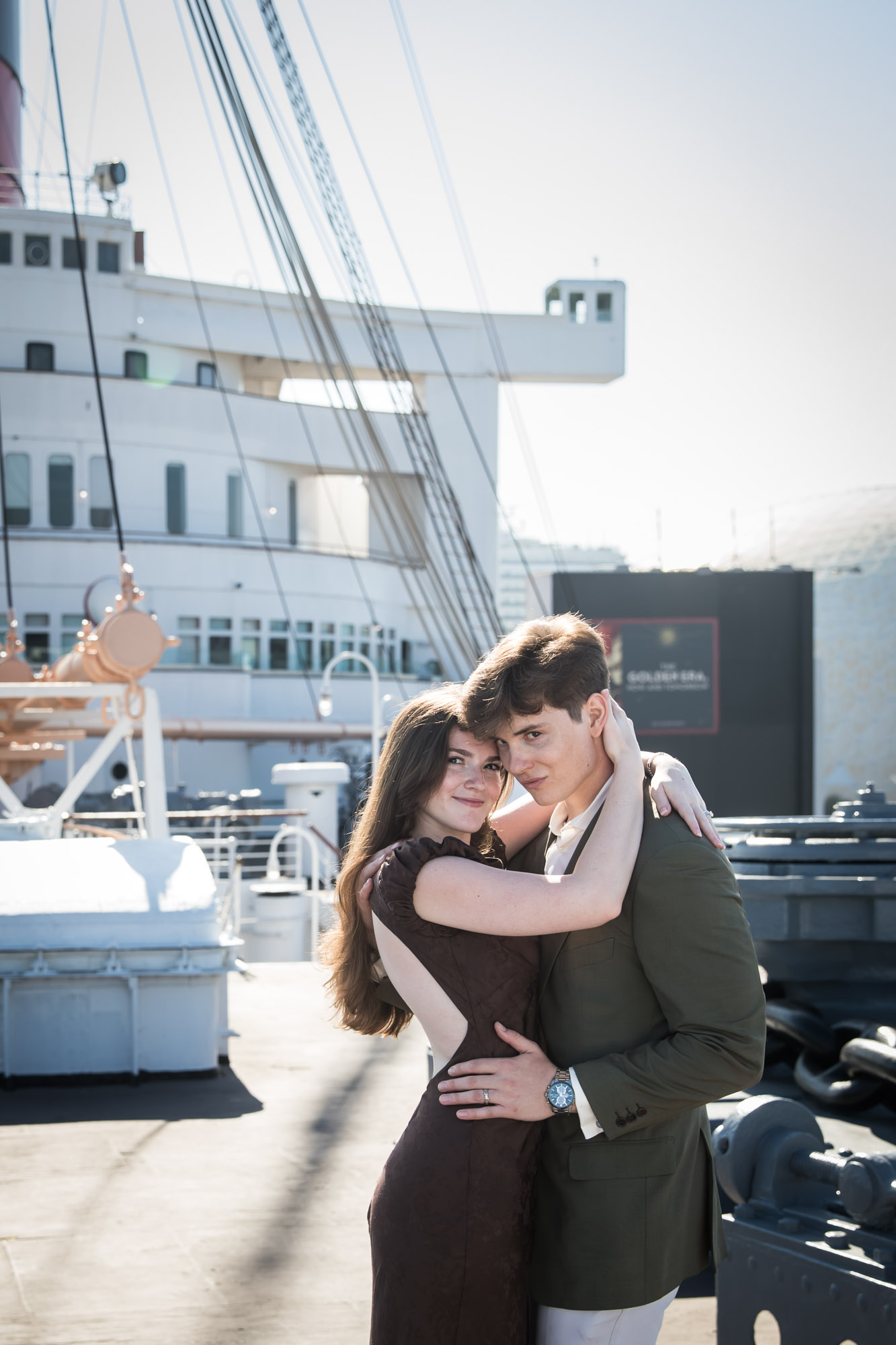 Couple pressing foreheads together in a tight embrace on deck, by a Long Beach photographer