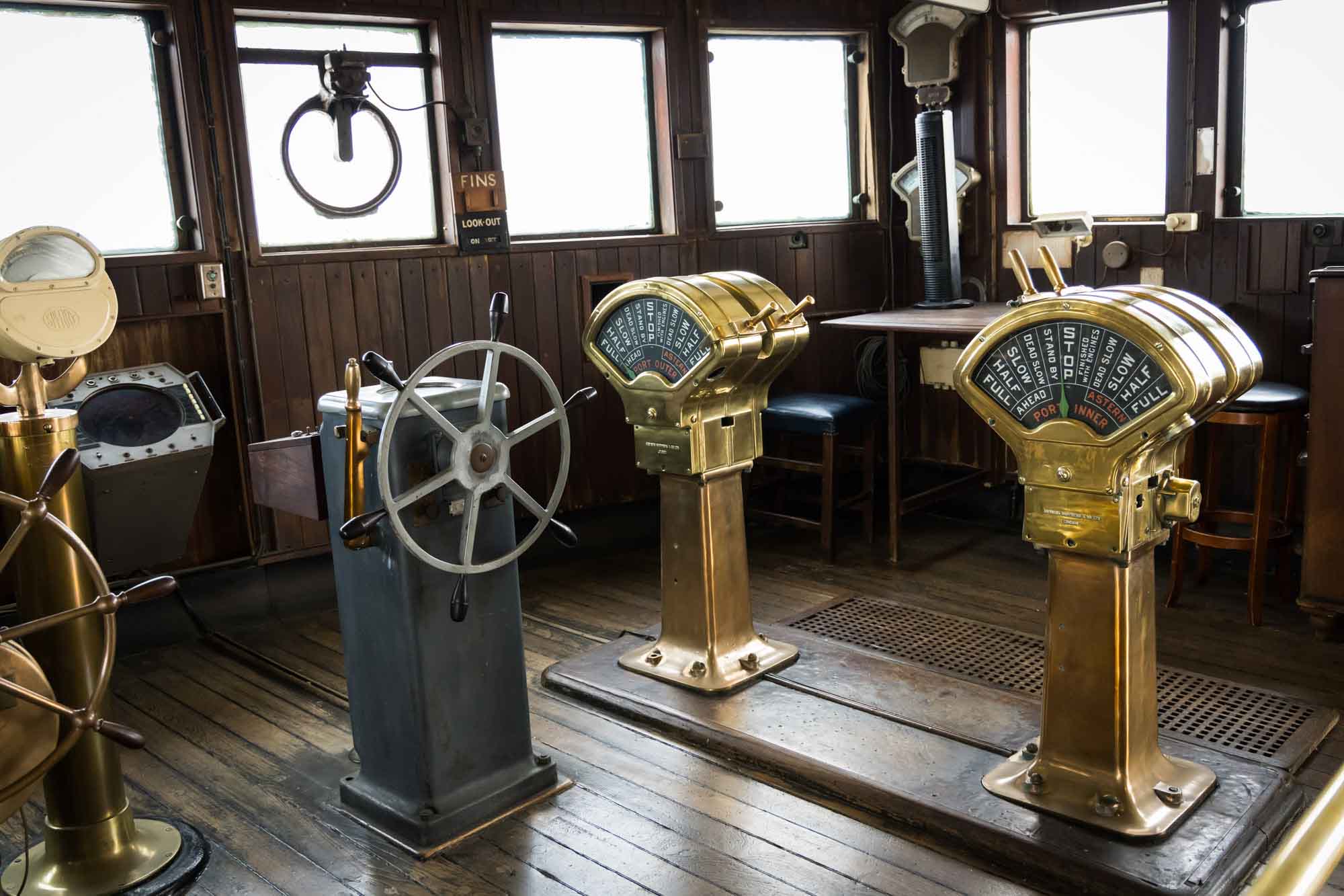Brass engine order telegraphs and a ship's wheel inside the Bridge wheelhouse, a detail-rich stop on a Queen Mary photo shoot