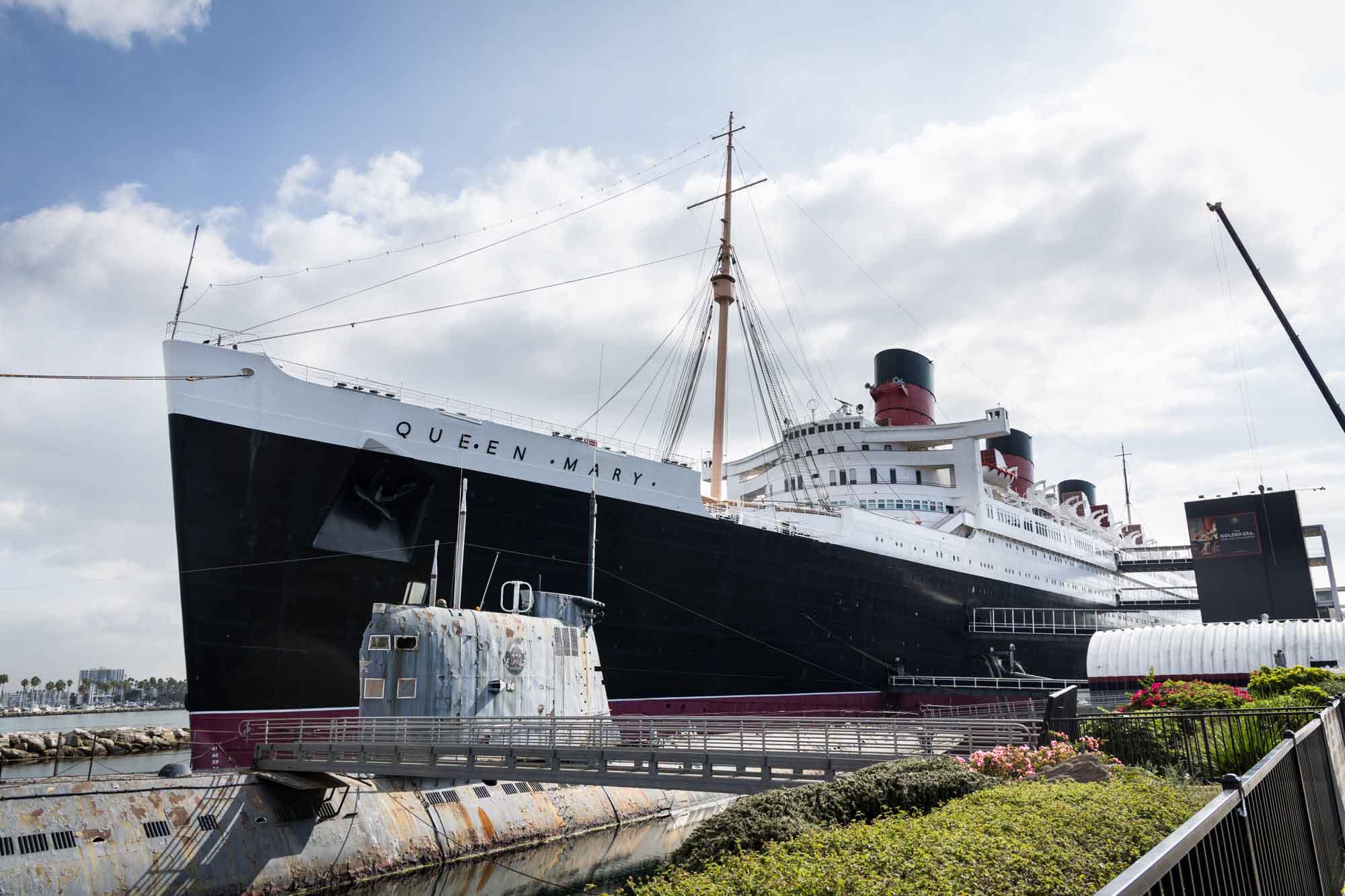 Full bow and hull of the Queen Mary with a submarine in the foreground, the ship that anchors every Queen Mary photo shoot