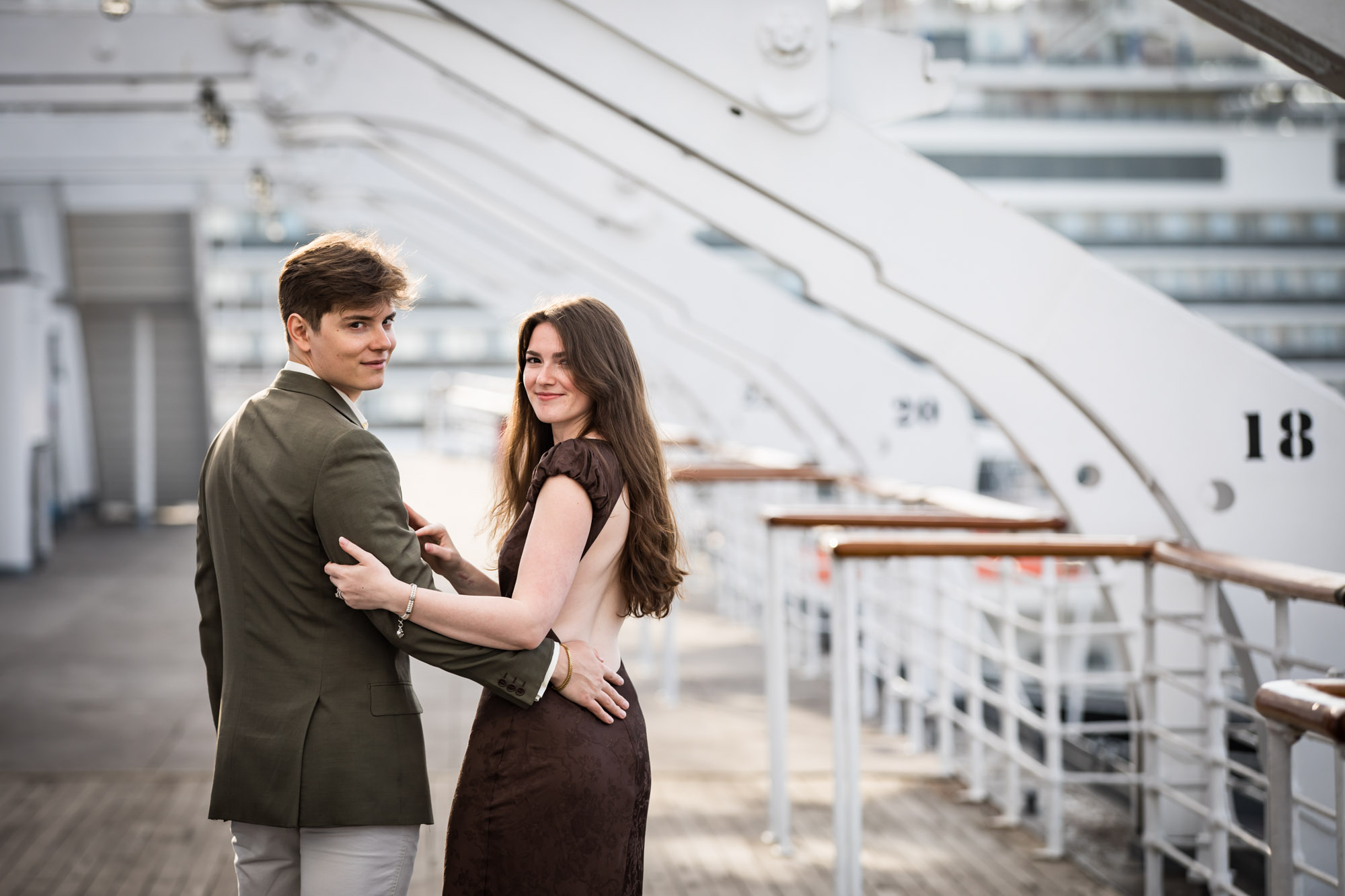Couple standing close and looking back at the camera, a pose from their Queen Mary photo shoot