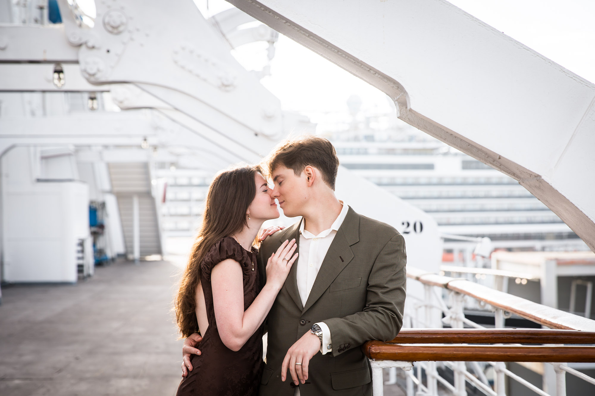 Couple nose to nose at the rail, a romantic moment from a Queen Mary photo shoot