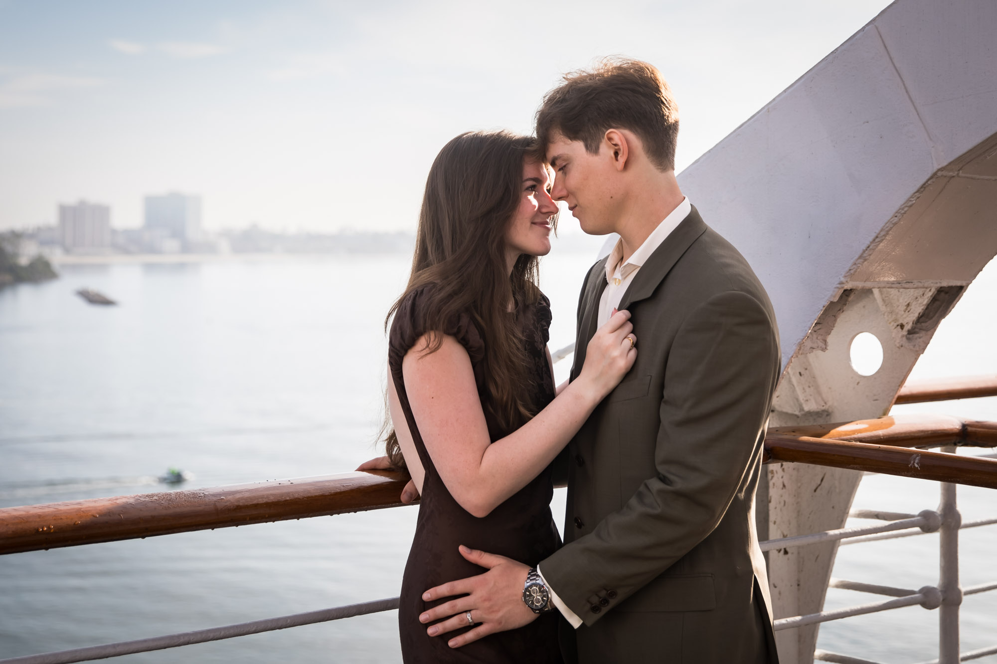 Couple nose to nose at the Queen Mary rail, a romantic moment from their Queen Mary photo shoot