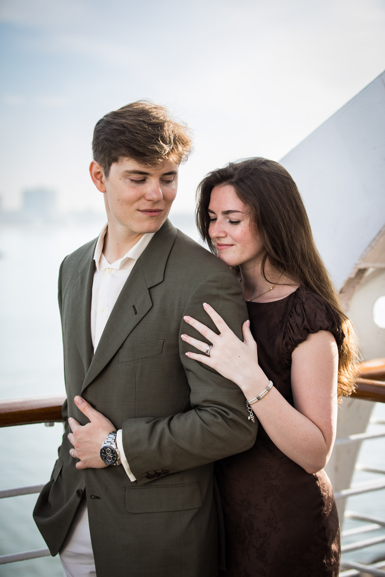 Woman resting her cheek on the man's shoulder with her eyes closed and her ring visible, photographed by a Los Angeles photographer