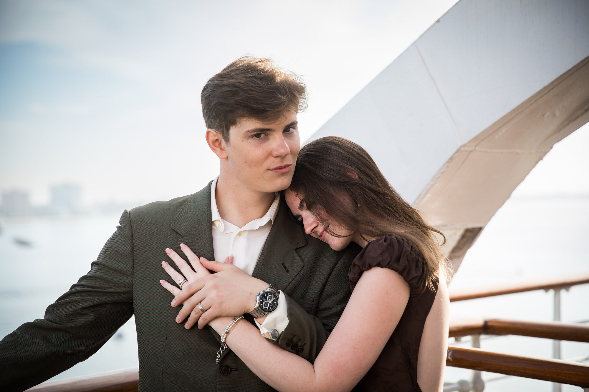 Woman leaning her head on the man's chest with her hands folded over his, photographed by a Los Angeles photographer