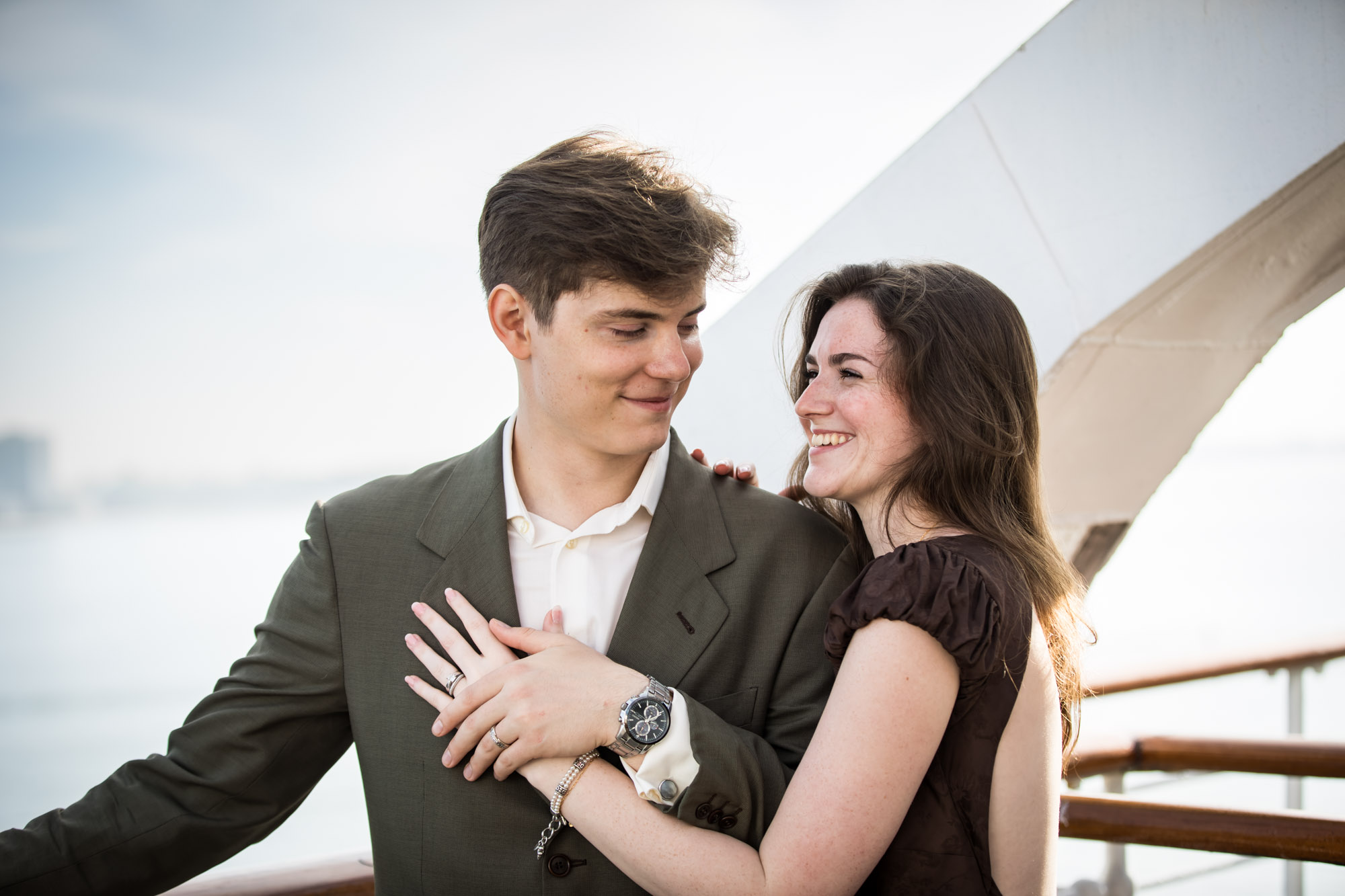 Woman laughing up at the man while he smiles down at her on the Queen Mary deck, a candid moment from their Queen Mary photo shoot
