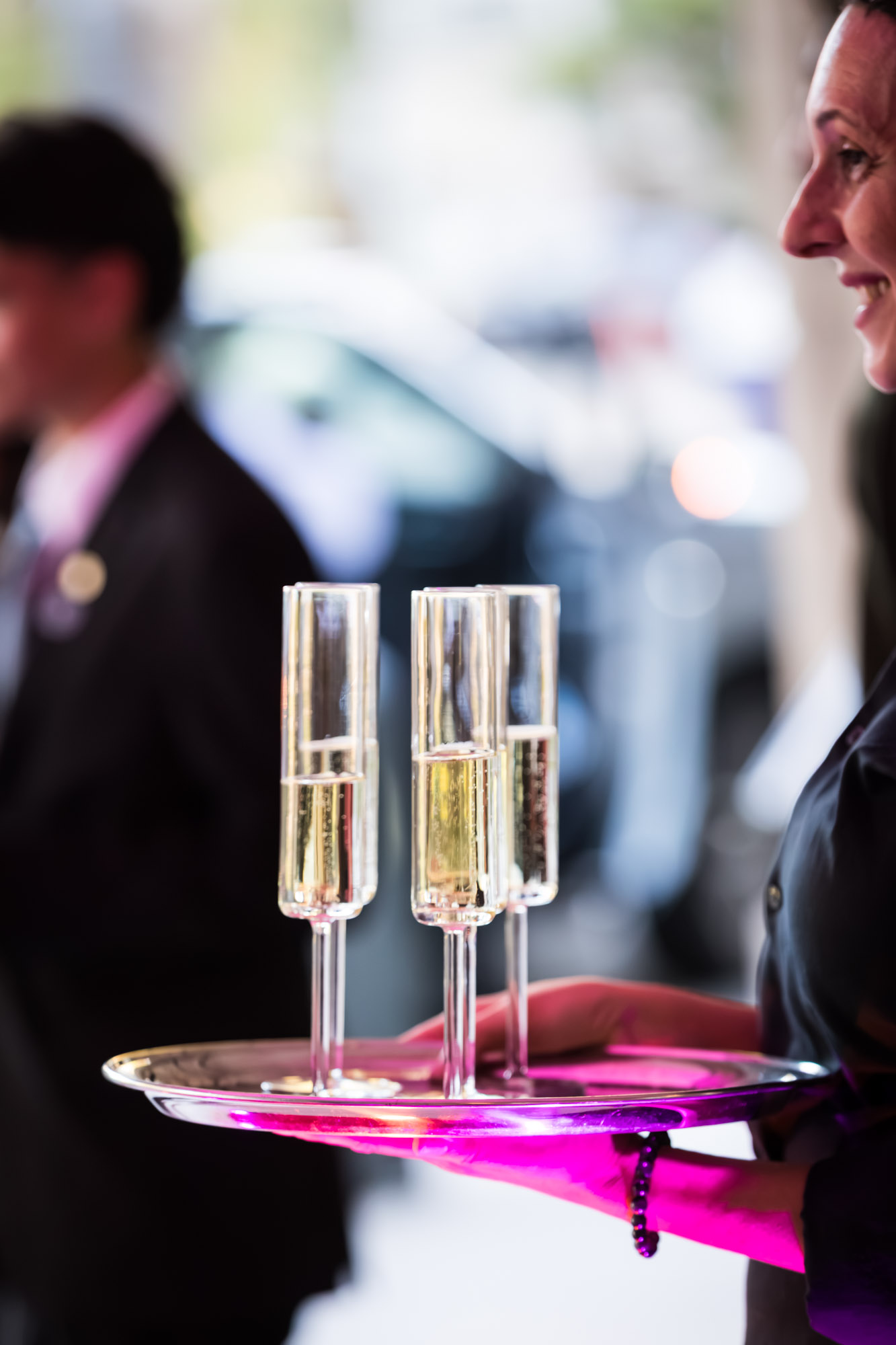 Raymond Theatre photos of champagne flutes on a silver tray lit pink during the guest arrival reception