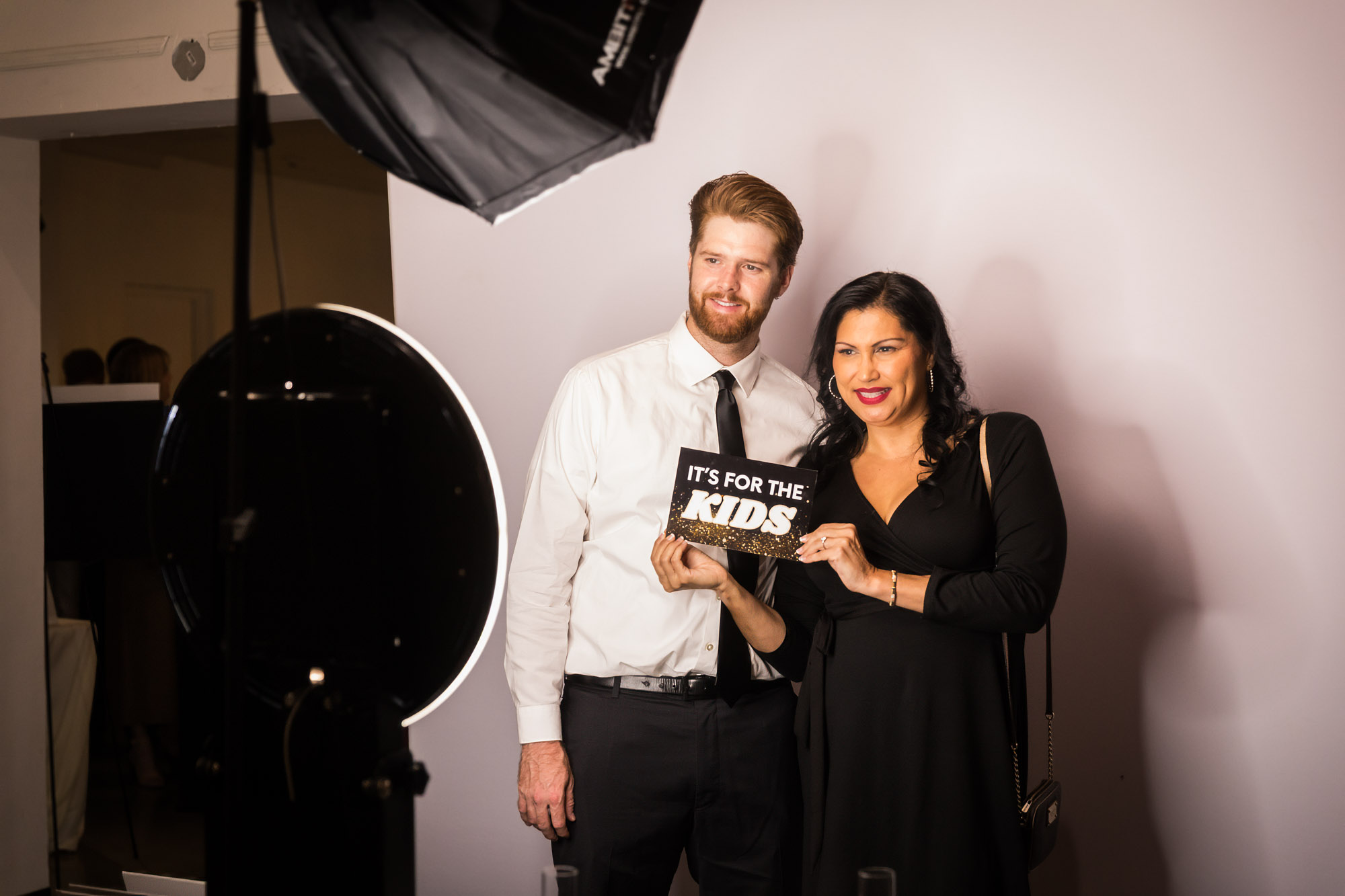 Los Angeles event photographer image of a couple holding an It's for the Kids sign at the photo booth