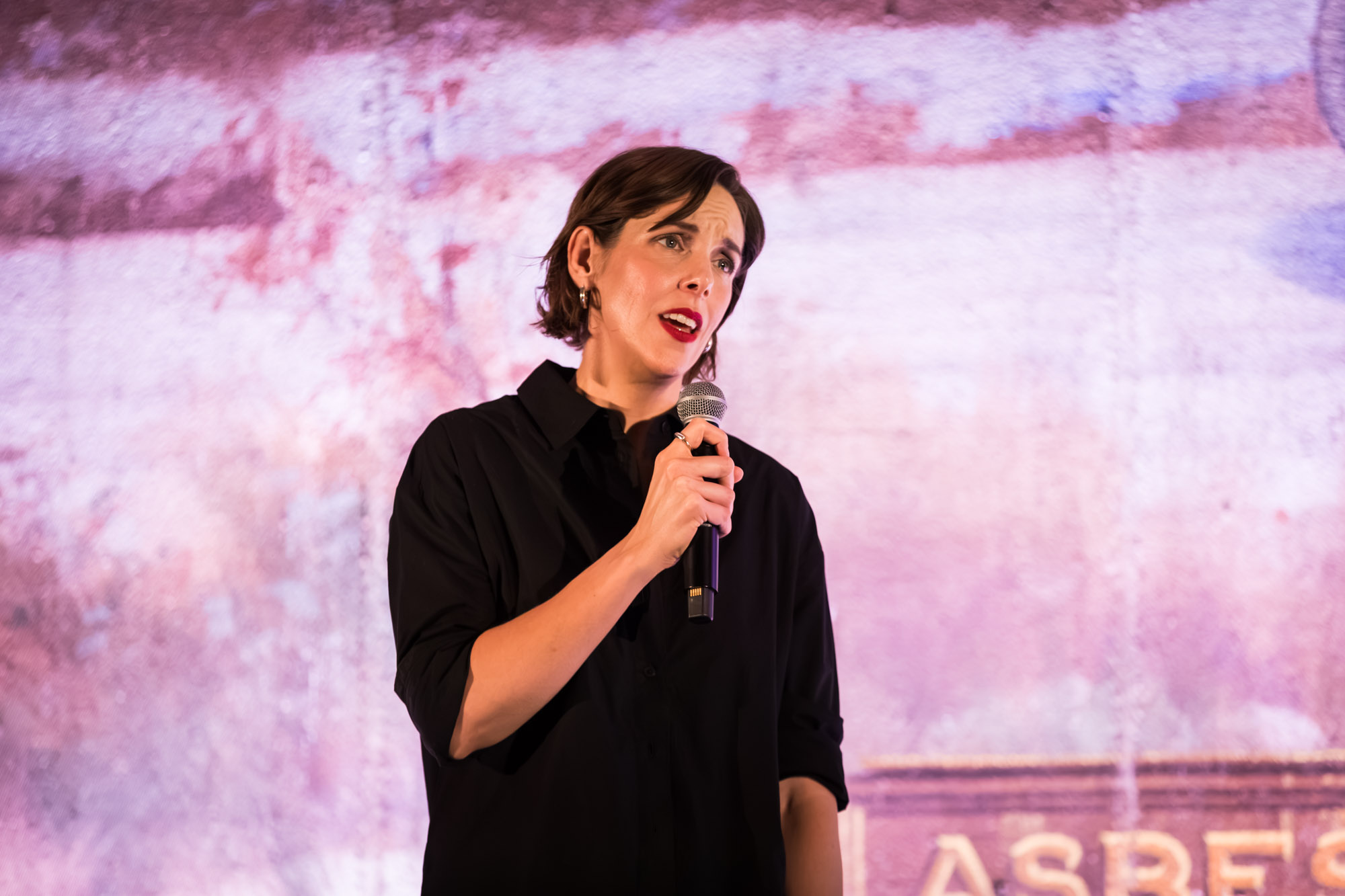 Los Angeles event photographer close-up of a woman in black speaking into a handheld microphone