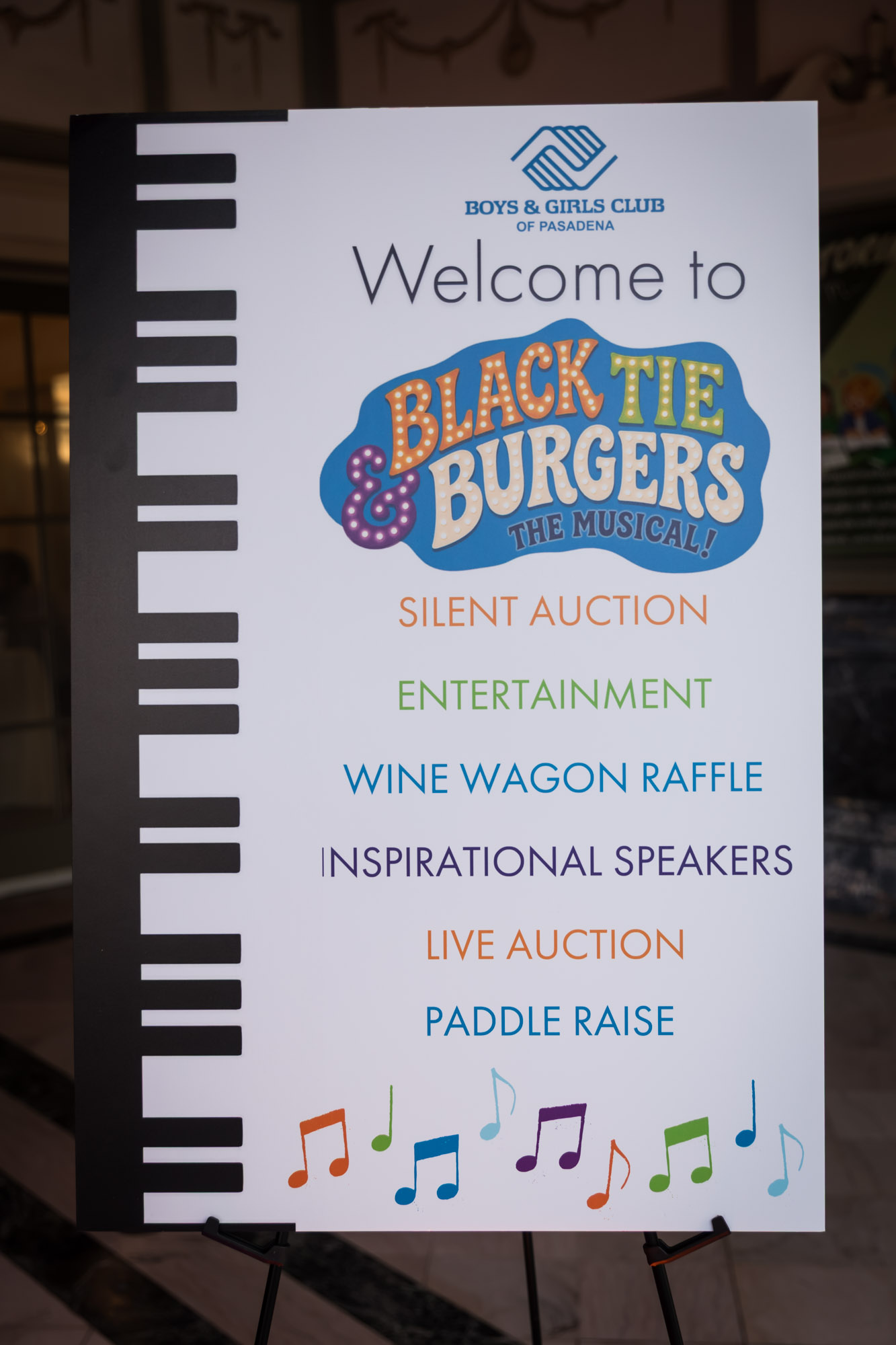 Raymond Theatre photos of the welcome sign listing silent auction, live auction, wine wagon raffle, and paddle raise